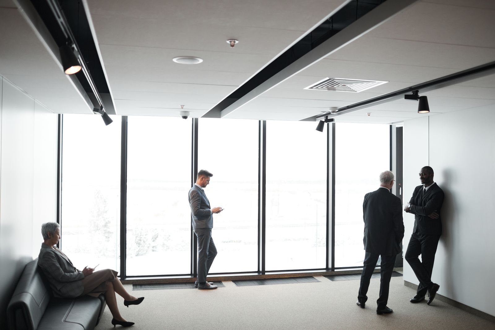 Diverse business professionals interacting in a bright, modern office setting.